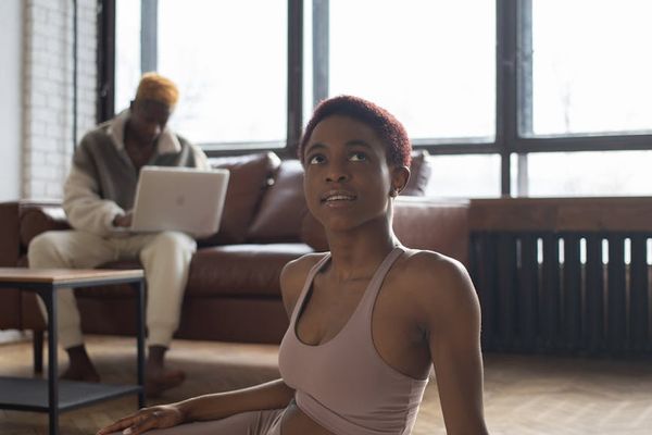 Person doing a stretching exercise in a bright, spacious room.